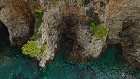 Insel-Kalamota,-Adria,-Kroatien-–-Das-Klare-Blaue-Wasser-Unter-Den-Steilen-Und-Schroffen-Klippen-–-Drohnenaufnahme-Aus-Der-Umlaufbahn