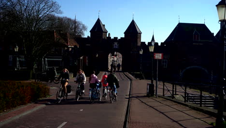 Mehrere-Radfahrer-Fahren-Vor-Dem-Historischen-Land--Und-Wassertor-Koppelpoort-In-Amersfoort-Vorbei