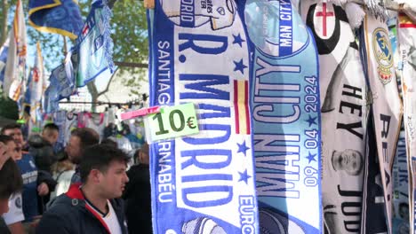 Real-Madrid-fans-buy-Real-Madrid-merchandise-scarves-before-attending-the-Champions-League-football-match-against-the-British-football-team-Manchester-City-at-the-Santiago-Bernabeu-stadium