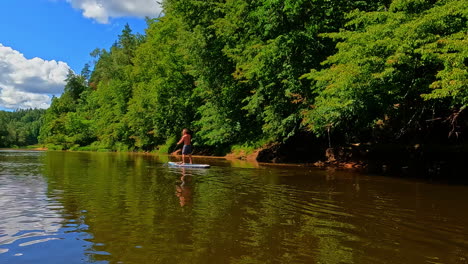 Young-man-standing-paddle-board-river-slow-motion-water-sport-activity-outdoor