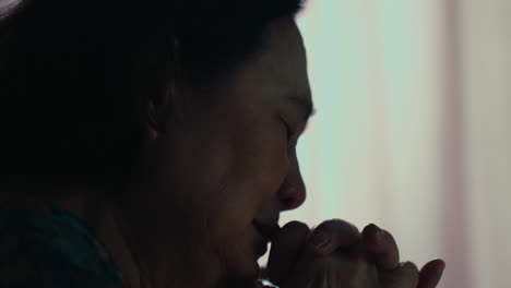 Nahaufnahme-Eines-Porträts-Einer-Asiatischen-älteren-Frau,-Die-Beim-Beten-Weint,-Trauer,-Einsamkeit,-Kummer-Und-Glaubenskonzept-