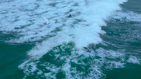 Drone-shot-of-surfers-playing-and-surfing-backwards-during-high-tide-in-Carlsbad-California