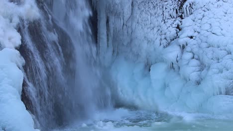 Closeup-or-falling-water-and-ice-covered-rocks