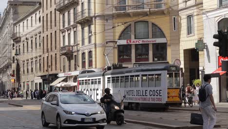 Men-go-cross-the-street-on-the-train-line-in-the-Milan-city-centre-in-Italy