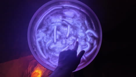 Nahaufnahme-Der-Hand,-Die-Im-Salzraum-Mit-Violetten-Lichtern-Spielt,-Alternativer-Therapiebehandlungsraum