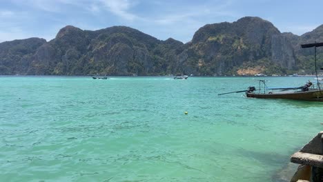 Boats-arriving-to-turquoise-waters-of-Tonsai-pier,-Phi-Phi-islands