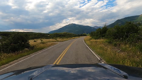 Passing-by-private-homestead-with-majestic-view-of-mountain-range,-driving-POV-shot