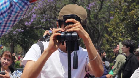 Hombre-Latino-Tomando-Una-Foto-Del-Eclipse-Solar-Desde-Una-Cámara-Réflex-En-Un-Trípode,-México-8-De-Abril-De-2024.