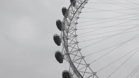 looking-up-at-a-skyward-perspective-capturing-the-The-London-Eye,-or-the-Millennium-Wheel,-against-the-backdrop-of-the-cloudy-London-sky,-evoking-the-essence-of-travel-and-exploration
