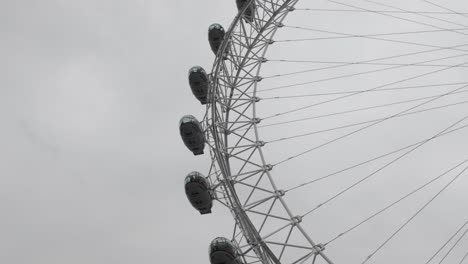 Blick-Nach-Oben-In-Eine-Himmelwärts-Gerichtete-Perspektive,-Die-Das-London-Eye-Oder-Das-Millennium-Wheel-Vor-Dem-Hintergrund-Des-Bewölkten-Londoner-Himmels-Einfängt-Und-Die-Essenz-Des-Reisens-Und-Der-Erkundung-Hervorruft