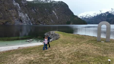 Young-tourists-walking-from-selfie-monument-to-beach-during-springtime-tour