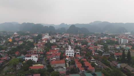 Top-aerial-view-of-Ninh-Binh-city-Vietnam-with-buildings-and-hills-in-the-background