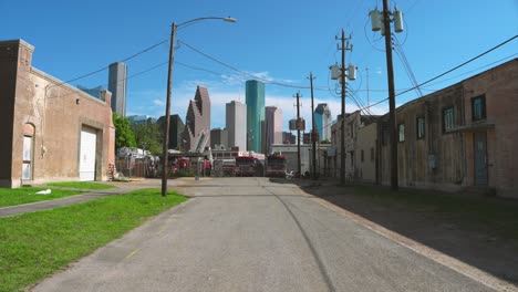 Toma-De-Escena-De-Un-Patio-Lleno-De-Camiones-De-Bomberos-Discapacitados-Con-El-Centro-De-Houston-Al-Fondo