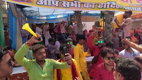 pov-shot-many-people-are-dancing-in-the-middle-of-the-road-and-also-shooting-in-mobile-where-different-people-are-flying-colors-and-many-people-are-watching