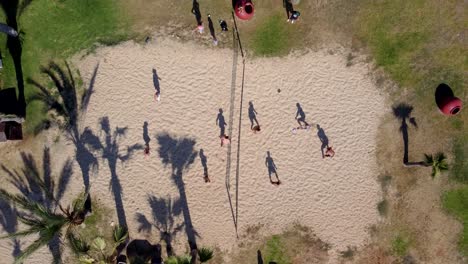 Vista-Superior-De-Un-Grupo-De-Personas-Jugando-Voleibol-De-Playa,-Actividades-Navideñas