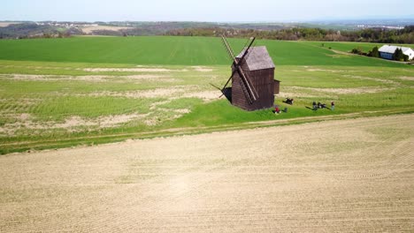 Nové-Dvory,-Bilovec,-Nový-Jičín-District,-Czech-Republic---Visitors-Discovering-the-Ancient-Windmill-Amidst-the-Tranquil-Rural-Landscape---Drone-Flying-Forward