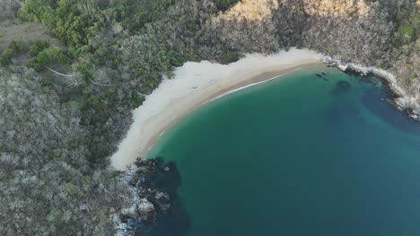 Drone-footage-of-Bay-El-Organo-at-sunset-in-Huatulco,-Oaxaca