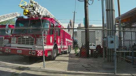 Einspielung-Eines-Hofes-Voller-Liegengebliebener-Feuerwehrautos-Mit-Der-Innenstadt-Von-Houston-Im-Hintergrund