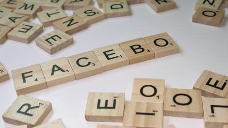 Nahaufnahme-Von-Buchstabensteinen-Aus-Dem-Scrabble-Spiel-In-Form-Des-Wortes-„Facebook“-Auf-Dem-Tisch