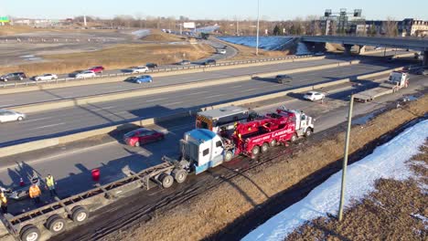 Tow-truck-removing-a-truck-that-suffered-an-accident-on-a-highway-in-Montréal,-Québec,-Canada