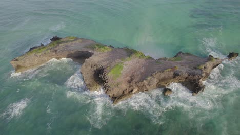 Revelación-Aérea-Toma-Matutina-De-Una-Isla-Rodeada-De-Olas-De-Agua.