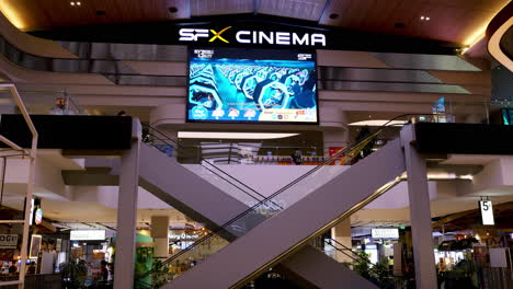 Moviegoers-going-up-the-escalator-to-the-cinemas,-while-shoppers-are-going-down-to-do-some-shopping-at-a-mall-in-Bangkok,-Thailand