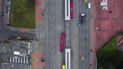 Top-down-drone-shot-above-traffic-in-Bogota-city,-cloudy-day-in-Colombia