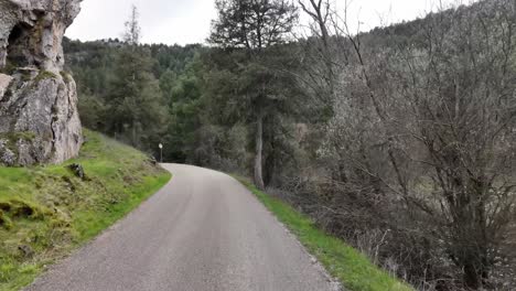 Driver-POV-while-driving-along-a-narrow-mountain-road-next-to-a-river-in-Soria,-Rio-Lobos-Canyon,-Spain