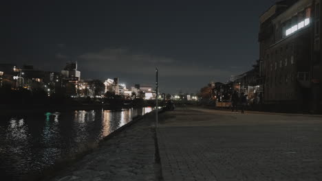 El-Tranquilo-Río-Kamo-Por-La-Noche-En-Una-Fría-Noche-De-Invierno-Con-Luces-De-Edificios-Y-Farolas-Al-Fondo