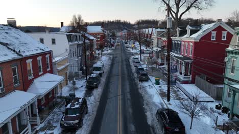 Aufsteigende-Drohnenaufnahme-Einer-Verschneiten-Stadt-Mit-Bunten-Häusern-In-Amerika