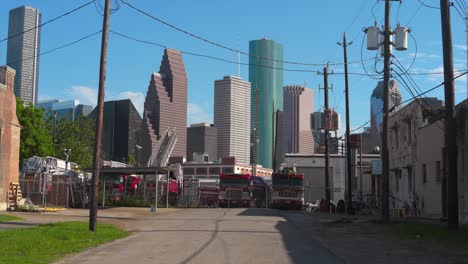 Toma-De-Escena-De-Un-Patio-Lleno-De-Camiones-De-Bomberos-Discapacitados-Con-El-Centro-De-Houston-Al-Fondo