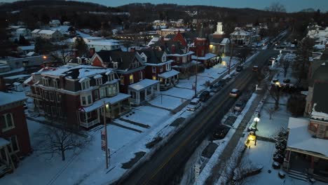 Snowy-winter-scene-of-american-town-with-houses,-street-and-church-in-dusk