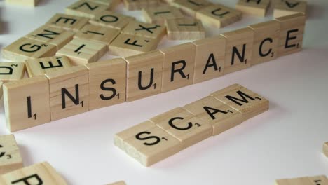 Concept:-Scrabble-tile-letters-form-words-INSURANCE-and-SCAM-on-table