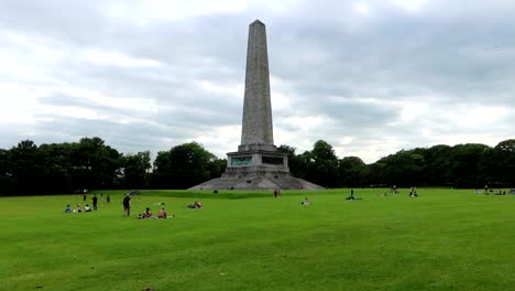 Menschen-Genießen-Die-Weite,-Grüne-Wiese-Rund-Um-Das-Wellington-Monument-Im-Phoenix-Park