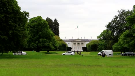 Facade-of-Aras-an-Uachtarain-seen-from-Phoenix-Park-with-the-Irish-flag-waving-in-the-wind