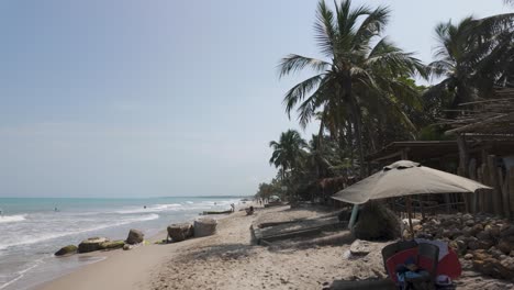 Langsame-Schwenkaufnahme-Von-Touristen,-Die-Den-Strand-Genießen-Und-In-Palomino-Surfen