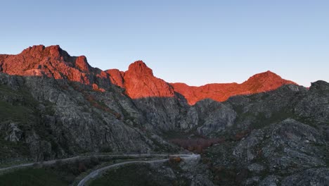 Rugged-Cântaros-massif-lit-up-at-sunrise-in-Serra-da-Estrela,-aerial-riser