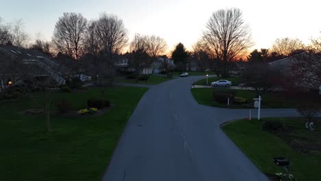 Drone-flight-over-street-of-luxury-suburb-homes-in-USA-at-golden-sunrise-at-sky