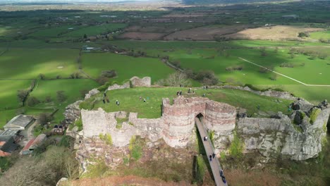Beeston-Castle-medieval-historic-landmark-in-the-springtime-sun---aerial-drone-rotate-around-and-pull-back---Cheshire,-England,-UK