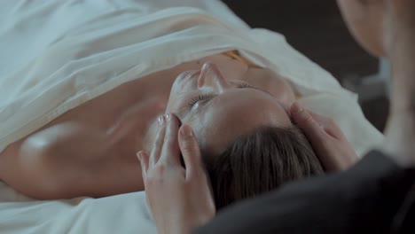 Slow-motion-close-up-shot-of-a-woman-receiving-a-head-massage-from-a-masseuse