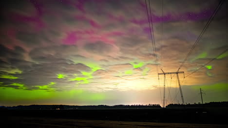 Clouds-roll-across-aurora-borealis-yellow-pink-green-lights-dancing-in-sky
