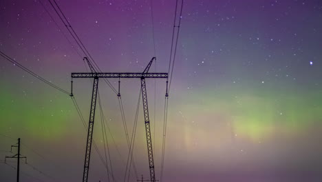 Northern-lights-timelapse,-purple-aurora-hues-with-green-shade-between-high-voltage-wire