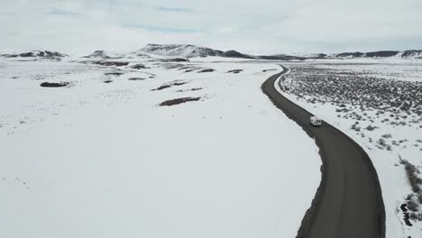 Aerial-view-of-a-motorhome-traveling-on-a-highway-in-Idaho-during-winter,-USA