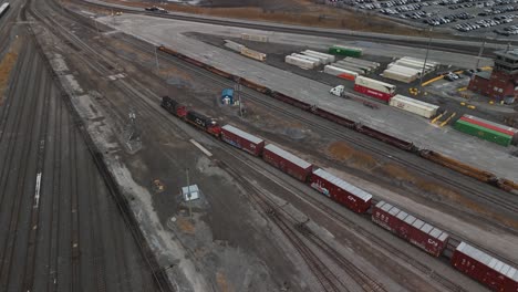 Vista-Aérea-Del-Tren-De-Carga-De-Contenedores-De-Carga-Acercándose-A-La-Estación-De-Tren-De-Saint-Laurent-En-Quebec,-Canadá,-Montreal