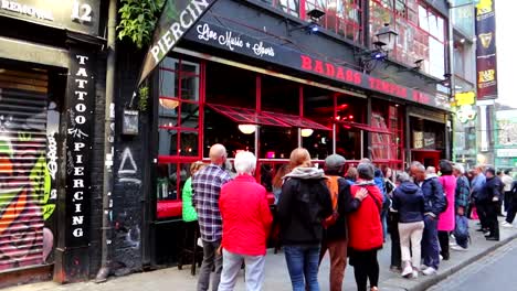 Pedestrians-enjoying-live-Irish-music-from-Bad-Ass-Cafe-in-Crown-Alley,-dolly-right-shot