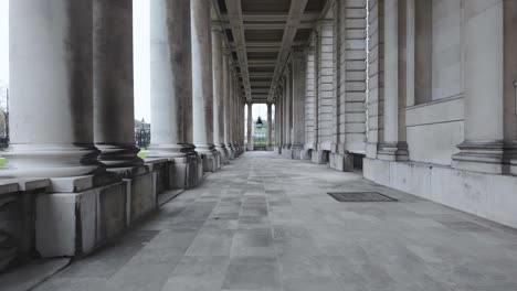 Walking-Through-The-Colonnade-At-The-Old-Royal-Naval-College-In-Maritime-Greenwich,-London,-United-Kingdom