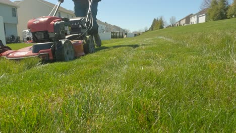 Man-pushing-mowing-grass-on-a-sunny-day