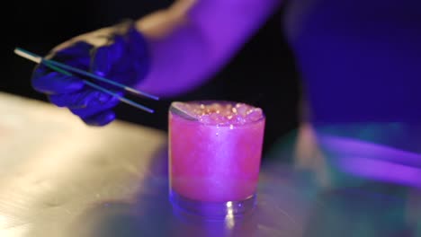 A-bartender-prepares-a-refreshing-alcoholic-drink-with-a-slice-of-lemon-in-a-glass