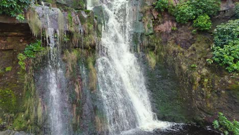 Aerial-drone-footage-of-a-tall-rocky-waterfall-in-the-Yorkshire-Dales,-Pennies