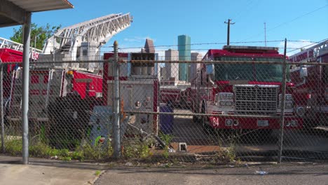 Toma-De-Escena-De-Un-Patio-Lleno-De-Camiones-De-Bomberos-Discapacitados-Con-El-Centro-De-Houston-Al-Fondo